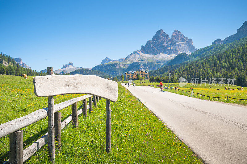 日出的观点空的道路和绿色草地的米苏里纳在Dolomites Famaus旅游景点与一个巨大的山后面在清晨。Cadore。威尼托。意大利。